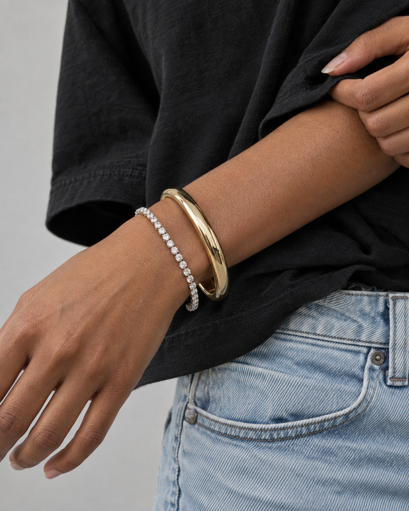 AI design reference: a model wearing a diamond tennis bracelet and a gold-tone bangle.